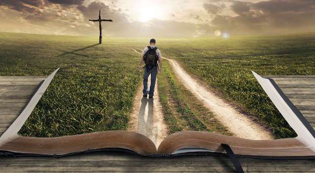 Man walking on a Bible towards a cross